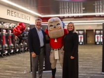 photo of two people with mascot