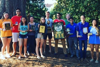 students with plaques, trophies