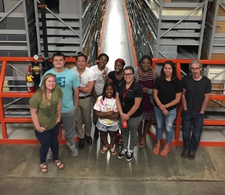 Photo of ten people in a warehouse interior