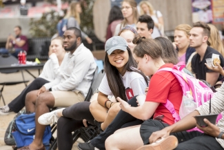 photo of seated outdoor crowd of spectators, two women in foreground