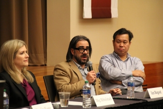 photo of three people, one holding microphone