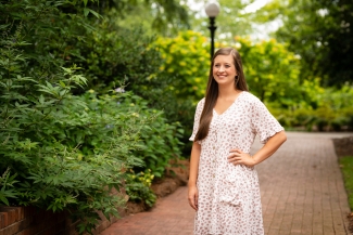 photo of woman standing on brick sidewalk