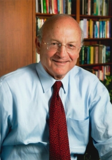 photo of man, bookshelves in background