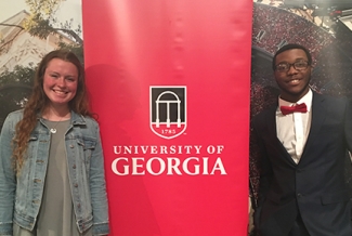 photo of two students with banner