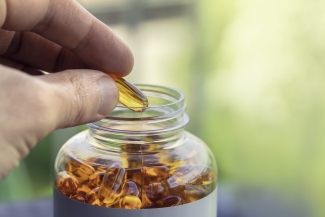 photo of hand with vitamins and bottle