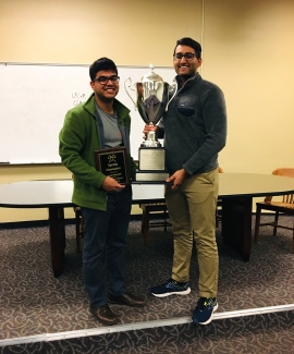 photo of two men with trophy and plaque