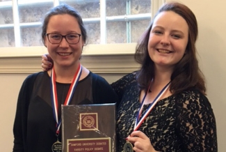 two women with plaque and medals