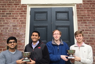 four students in front of Phi Kappa door