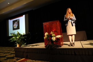 photo of woman next to podium on dais