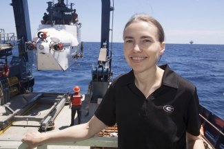 photo of woman aboard ship, ocean in background