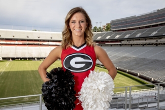 photo of woman in cheerleading outfit at stadium