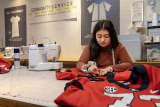 photo of woman sewing a red jersey