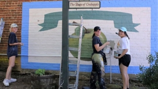 photo of three women painting a mural