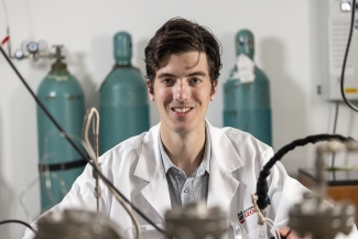 photo of man in lab coat, with lab equipment