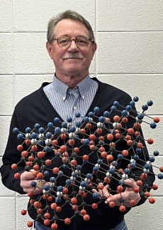 photo of man holding a crystal model