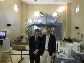 photo of men with NMR machine in background 