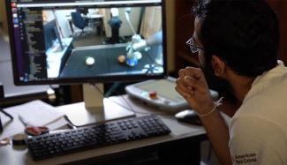 video still image of man looking at computer screen