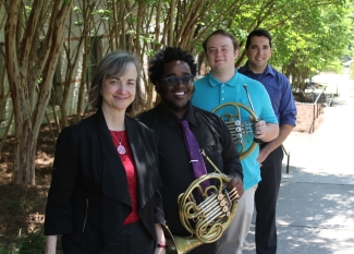 photo of four musicians, two holding horns