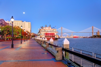 photo of docked riverboat, river, bridge in background