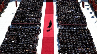 photo of student walking across red carpet at commencement