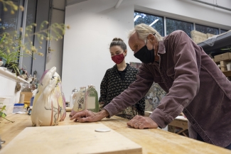 photo of two people in masks in art studio