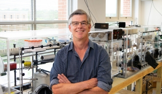 photo of man in research lab, arms folded