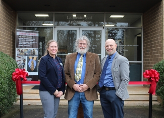 photo of woman and two men in front of building