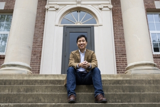 photo of man sitting on building steps 