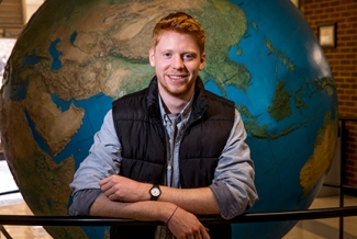 photo of man in front of globe