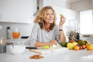 photo of woman leaning on counter, with healthy fruits