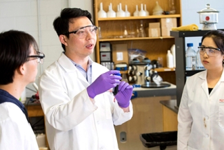 photo of man and students in lab coats