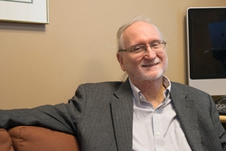 photo of man, seated with monitor