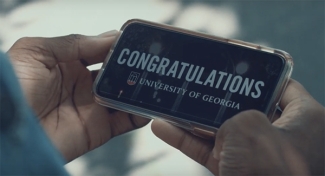 photo of hands holding a cell phone with congratulations