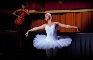 photo of ballerina, with cellist in the background