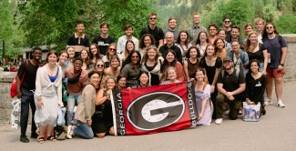 group photo of people, with super 'G' flag at center