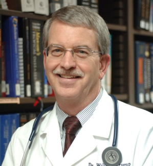 headshot of man, with books in background