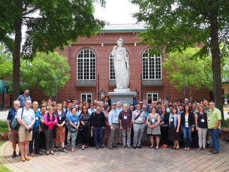 photo of large group of people with statue outdoors