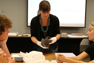 professor with artifact, students