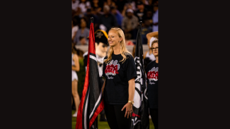 photo of woman on field, with flag