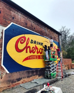 photo of students with lift, painting mural