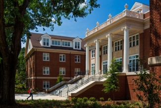 photo of building, day, blue sky, with person approaching staircase