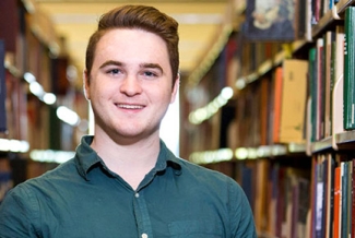 man with library shelves and books