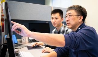 photo of two men at a computer screen