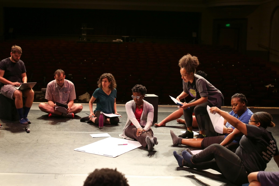 Dr. Julie B. Johnson (Spelman – Dance Performance & Choreography) on box, and Dr. Amma Y. Ghartey-Tagoe Kootin (UGA – Theatre and Film Studies/Institute for African American Studies) sitting w/ paper and Dr. Emily Sahakian (UGA – Theatre and Film Studies/Romance Languages) in teal shirt, and students from the multi-class, multi-school collaborative project. Image by Shannah Montgomery