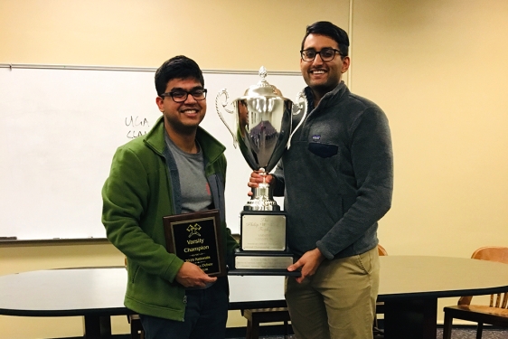 photo of two men with trophy and plaque