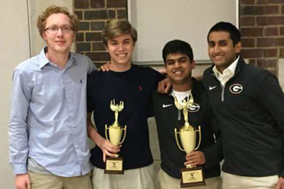 four male students with trophies