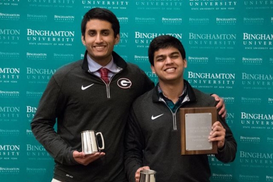 two students with plaque and cups