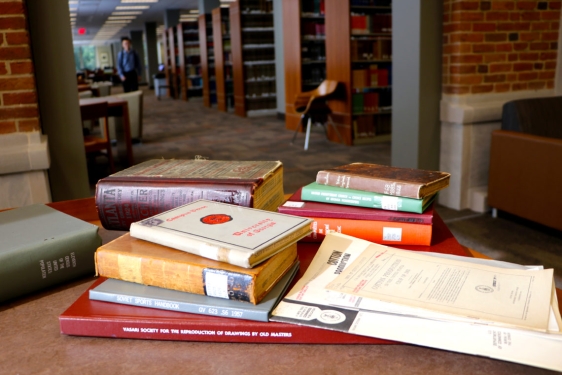 photo of books stacked on a table in a library 