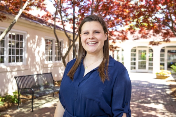 photo of woman outside of building with trees