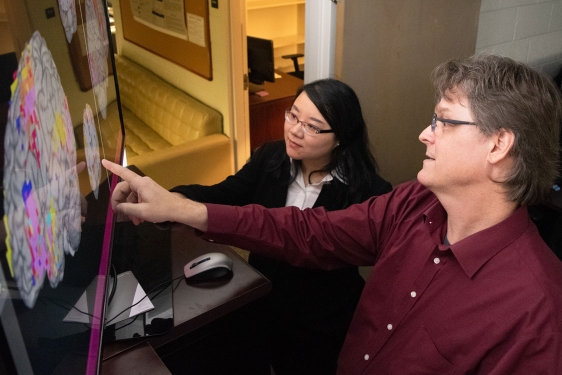 photo woman and man pointing to computer screen